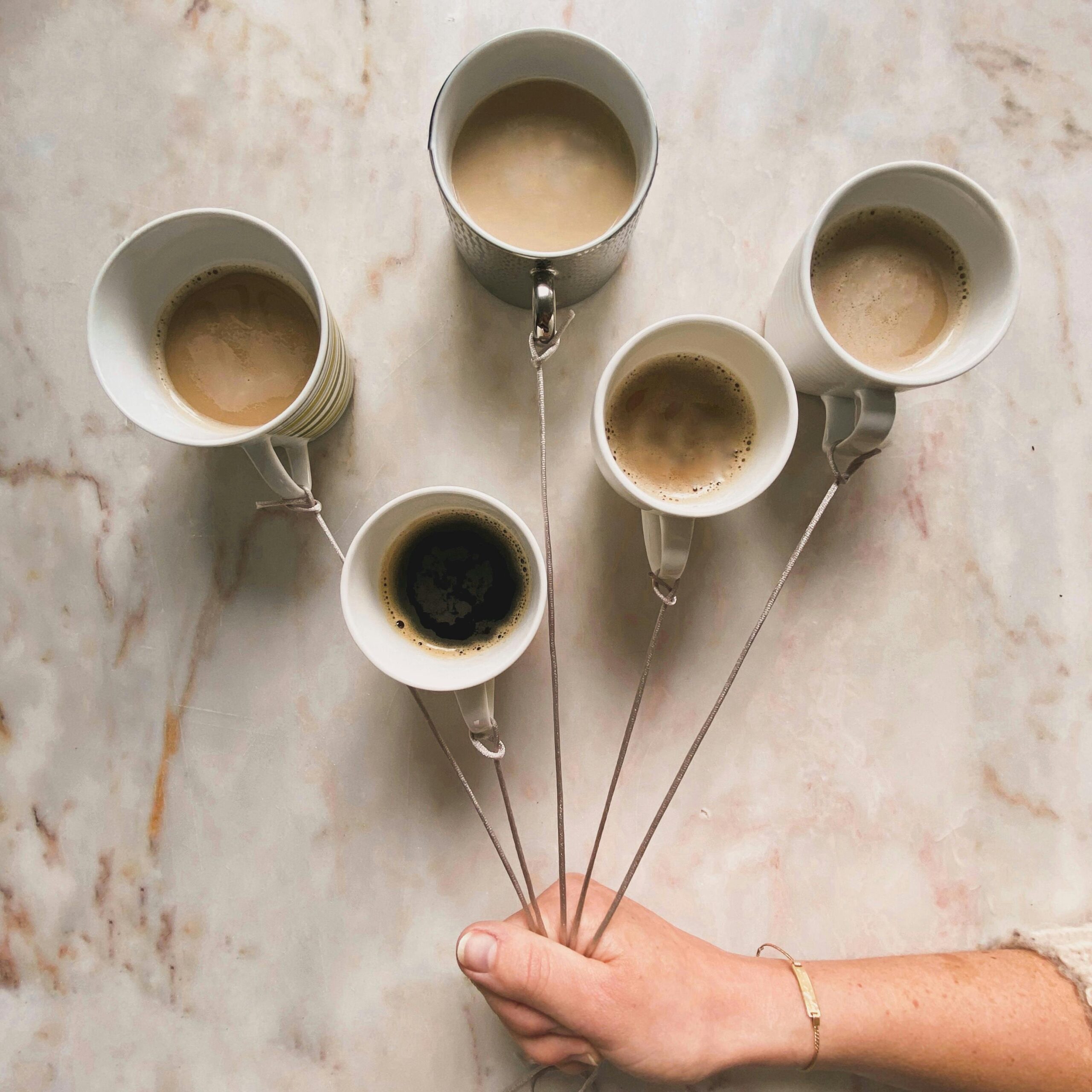 Five cups of coffee connected with wire, symbolizing high volume grant opportunities. 