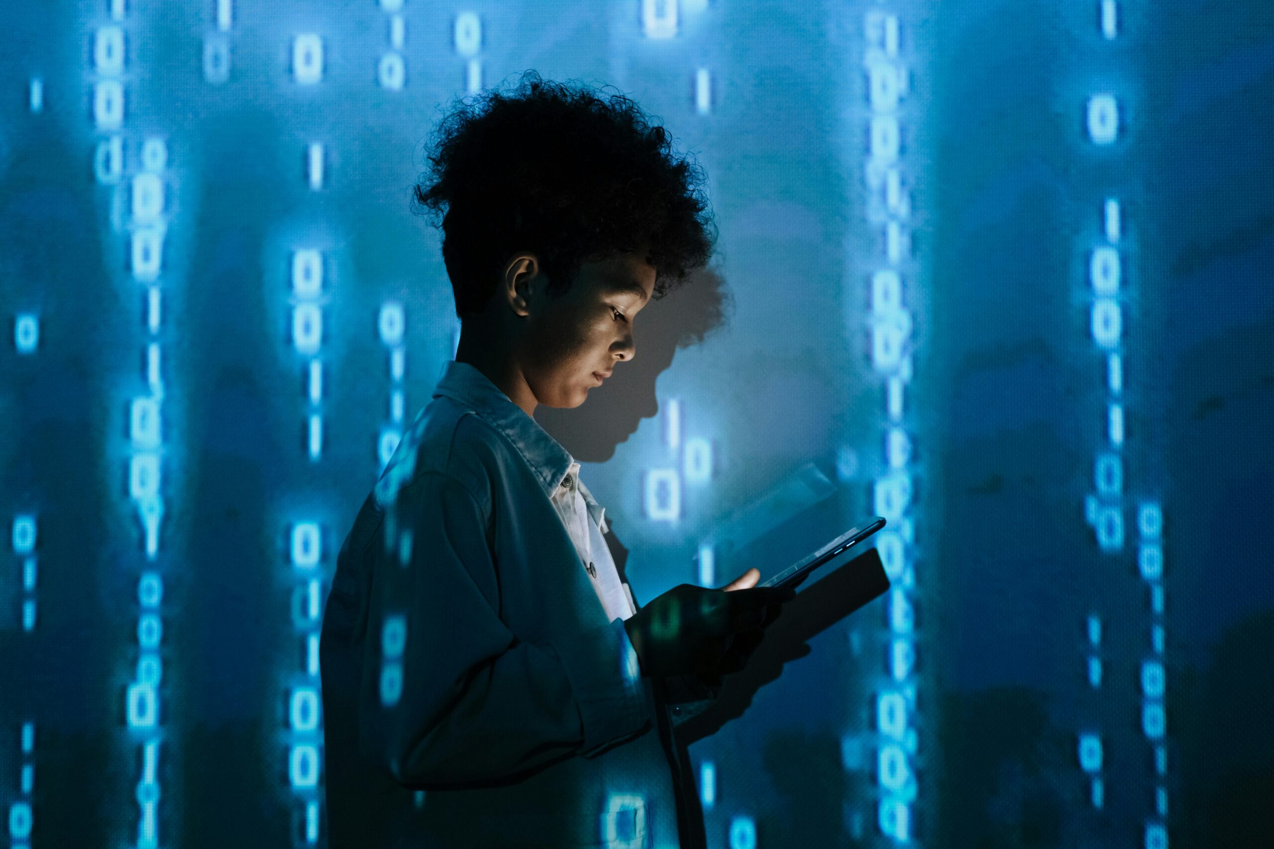 A person holding a tablet with a blue tech background. 