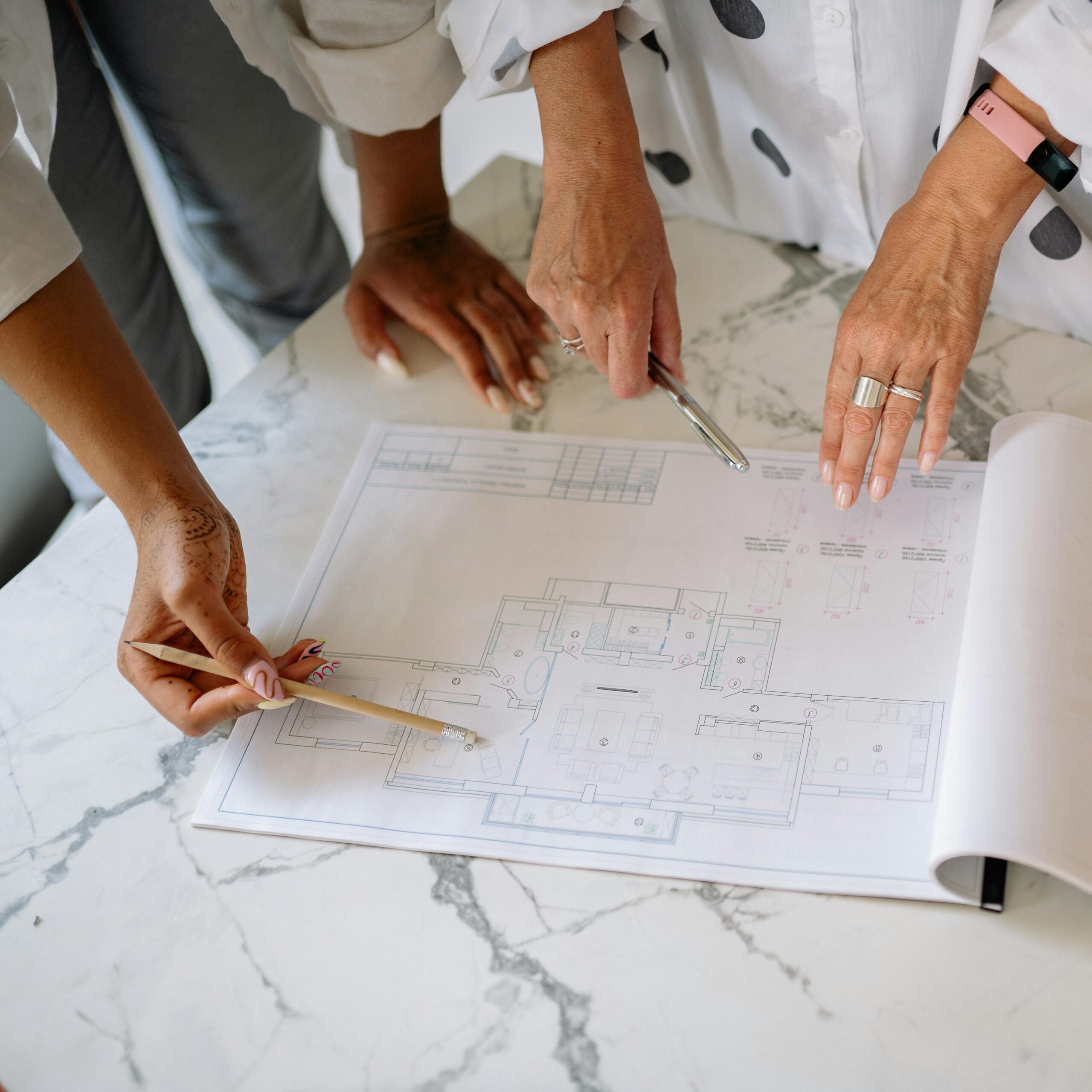 pexels-yankrukov-8837715 Two people going over construction blueprints.